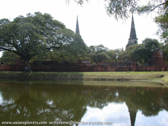 A lake in the Royal Palace grounds, with the chedis of Wat Phra Si Sanphet outside the wall